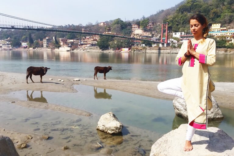 Carmen Mar Yoga Vrksasana Treepose in front of Ram Jula Ganges river Rishikesh with cows