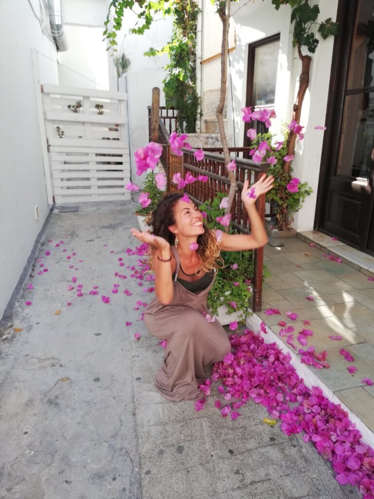 Happy Carmen Mar throughing up petals in a backyard